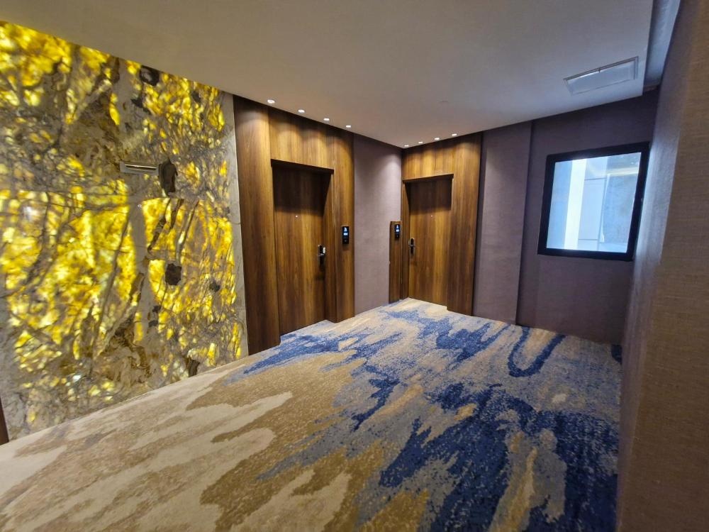 Hotel in Kuwait corridor with abstract wall art and blue carpet