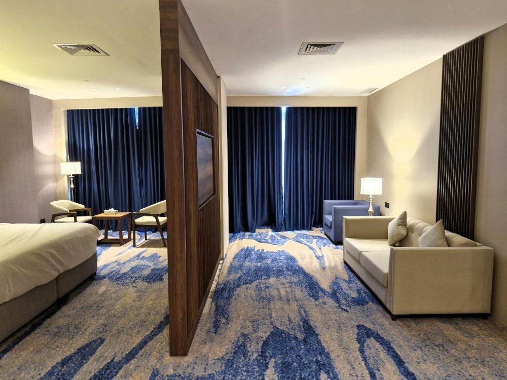Spacious Hotel in Kuwait room with beds sofa and blackout curtains
