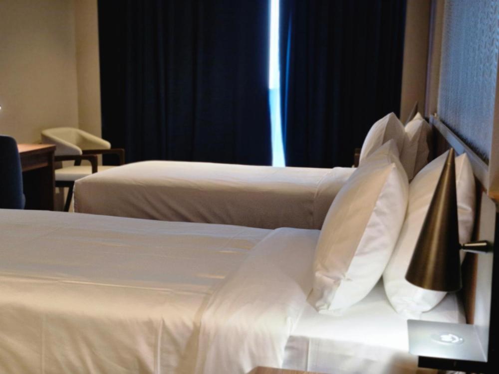 Twin bed setup at Hotel in Kuwait with blackout curtains