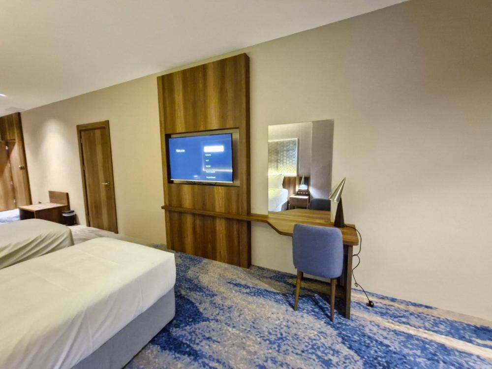Guest room at Ocean View Hotel Kuwait with wall-mounted TV