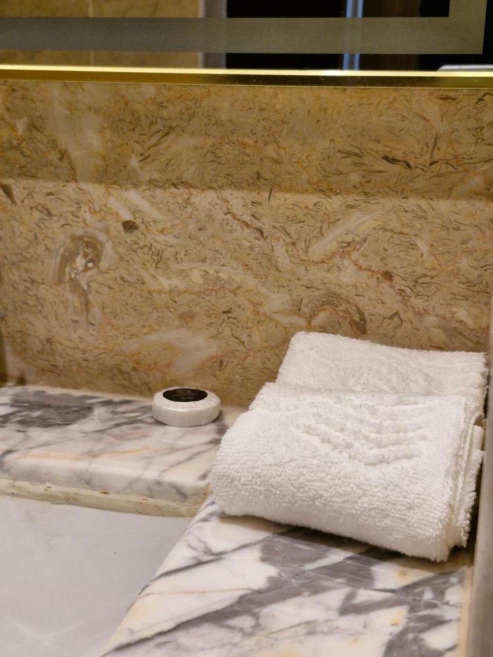 Hotel in Kuwait vanity counter with marble surface and folded towel